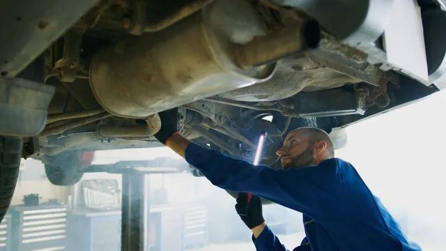 Illustrative photograph of a mechanic inspecting the underside of a raised vehicle