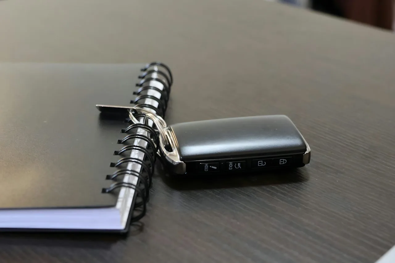 Illustrative photograph of a car key beside a notebook